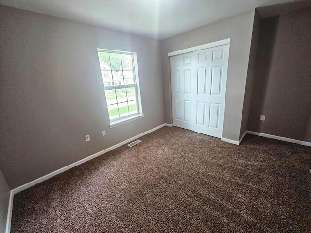 441 8th Ave SW, Cedar Rapids, IA 52404 - unfurnished bedroom with dark colored carpet and a closet
