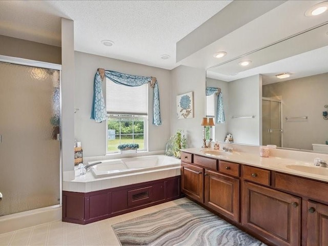 725 High Point Dr SW, Cedar Rapids, IA 52404 - bathroom featuring a stall shower, a bath, double vanity, recessed lighting, and a textured ceiling