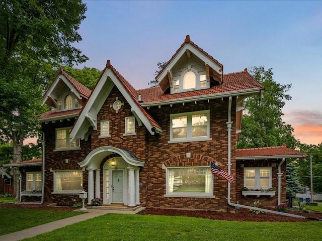 206 Kingbard Blvd, Waterloo, IA 50701 - view of front of property with a yard, a tiled roof, and brick siding