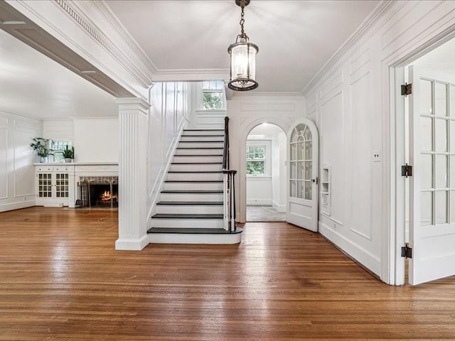 206 Kingbard Blvd, Waterloo, IA 50701 - entrance foyer with a decorative wall, hardwood / wood-style floors, stairway, ornamental molding, and a lit fireplace