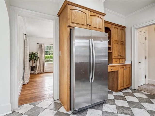 206 Kingbard Blvd, Waterloo, IA 50701 - kitchen with freestanding refrigerator, crown molding, brown cabinetry, light countertops, and light tile patterned floors