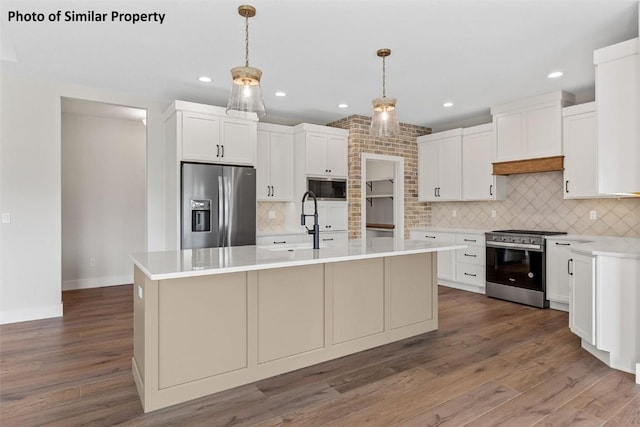 6706 Lauder Ln NE, Cedar Rapids, IA 52411 - kitchen with appliances with stainless steel finishes, tasteful backsplash, light countertops, wood finished floors, and white cabinetry