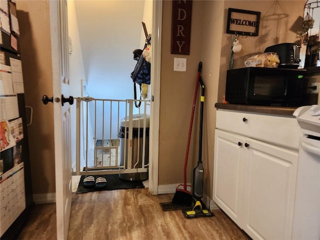 904 10th St, Belle Plaine, IA 52208 - doorway to outside featuring wood finished floors and water heater