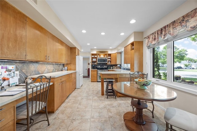 1104 Mulberry St, Tipton, IA 52772 - kitchen with stainless steel appliances, tasteful backsplash, recessed lighting, open shelves, and light countertops