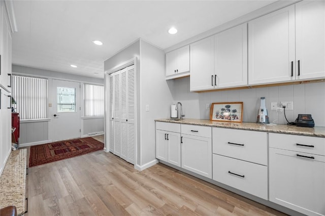 1104 Mulberry St, Tipton, IA 52772 - kitchen featuring light wood-style floors, white cabinetry, light stone counters, and recessed lighting