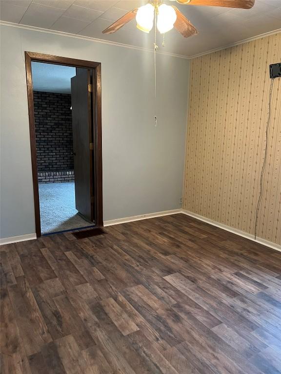 201 S 8th Ave, Vinton, IA 52349 - spare room featuring a ceiling fan, crown molding, and dark wood finished floors