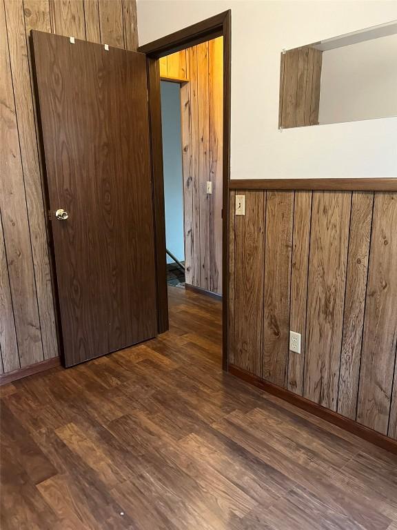 201 S 8th Ave, Vinton, IA 52349 - unfurnished room featuring dark wood-style flooring and wooden walls