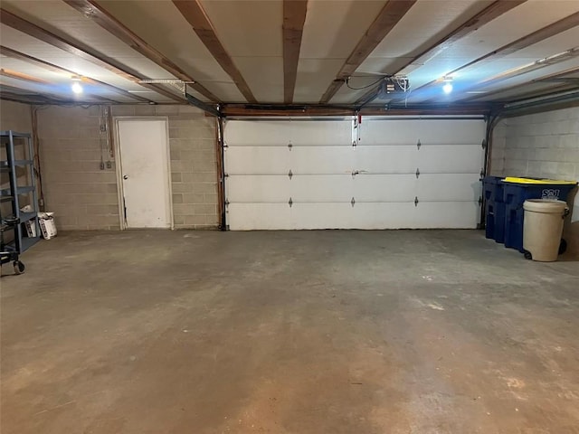 201 S 8th Ave, Vinton, IA 52349 - garage featuring a garage door opener and concrete block wall