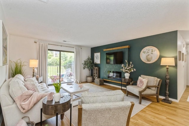 2135 1st Ave SE Unit 125, Cedar Rapids, IA 52402 - living room with a textured ceiling, light wood-style floors, and an accent wall