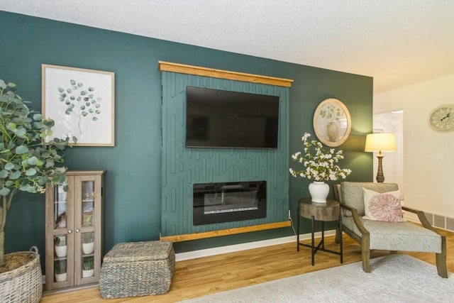 2135 1st Ave SE Unit 125, Cedar Rapids, IA 52402 - living room with wood finished floors and a glass covered fireplace
