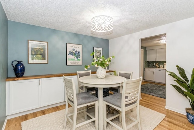 2135 1st Ave SE Unit 125, Cedar Rapids, IA 52402 - dining room with light wood-style flooring and a textured ceiling