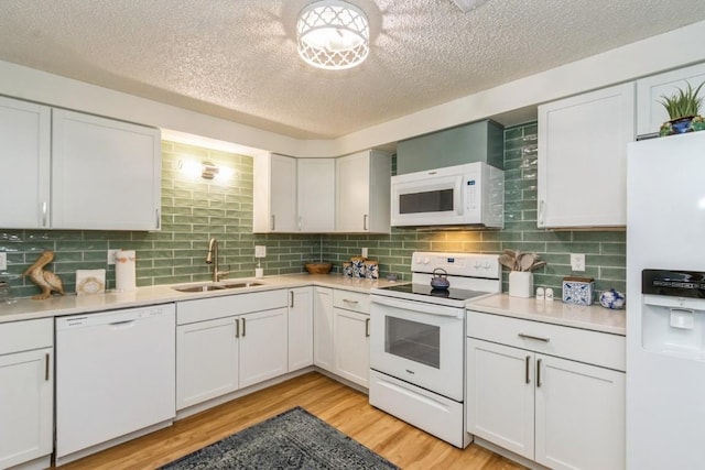 2135 1st Ave SE Unit 125, Cedar Rapids, IA 52402 - kitchen featuring white appliances, a textured ceiling, light countertops, light wood-style flooring, and decorative backsplash