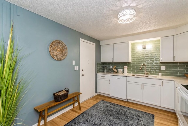 2135 1st Ave SE Unit 125, Cedar Rapids, IA 52402 - kitchen with dishwasher, a textured ceiling, decorative backsplash, light countertops, and light wood-style flooring