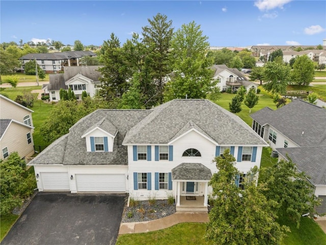 4309 Woodsonia Ct NW, Cedar Rapids, IA 52405 - colonial home featuring asphalt driveway, a residential view, a garage, and a shingled roof