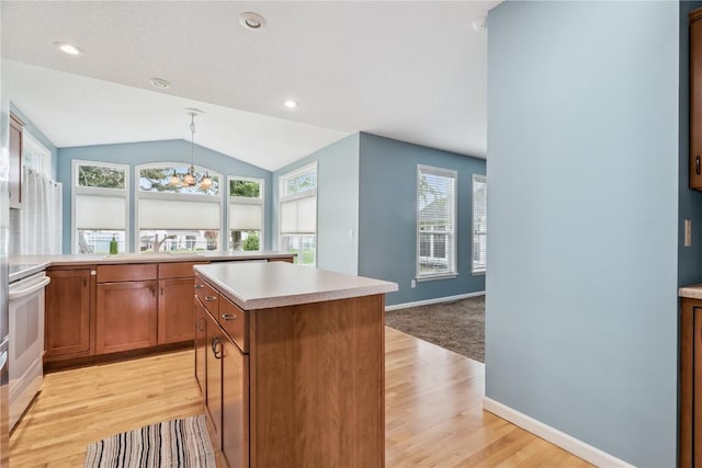4309 Woodsonia Ct NW, Cedar Rapids, IA 52405 - kitchen with light wood finished floors, light countertops, brown cabinets, lofted ceiling, and a center island