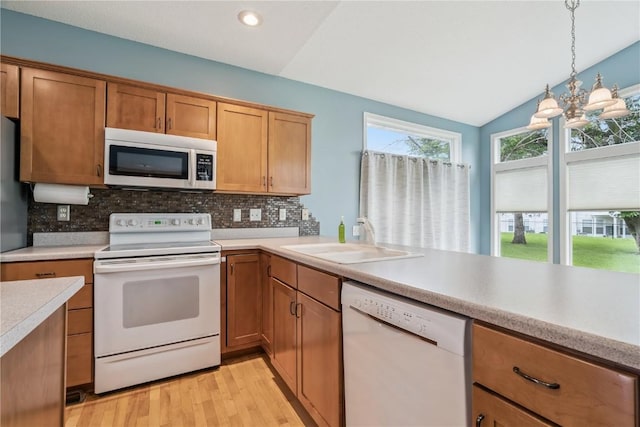 4309 Woodsonia Ct NW, Cedar Rapids, IA 52405 - kitchen with white appliances, light countertops, decorative backsplash, light wood-style floors, and decorative light fixtures