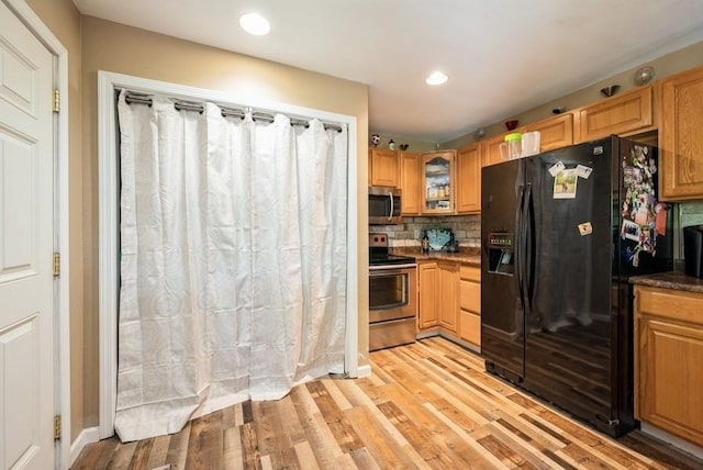 4524 Benton St, Cedar Rapids, IA 52402 - kitchen featuring stainless steel appliances, light wood-style flooring, backsplash, recessed lighting, and dark countertops