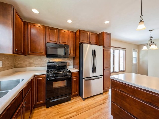 4634 Twin Pine Dr NE, Cedar Rapids, IA 52402 - kitchen with black appliances, light countertops, light wood finished floors, decorative light fixtures, and tasteful backsplash