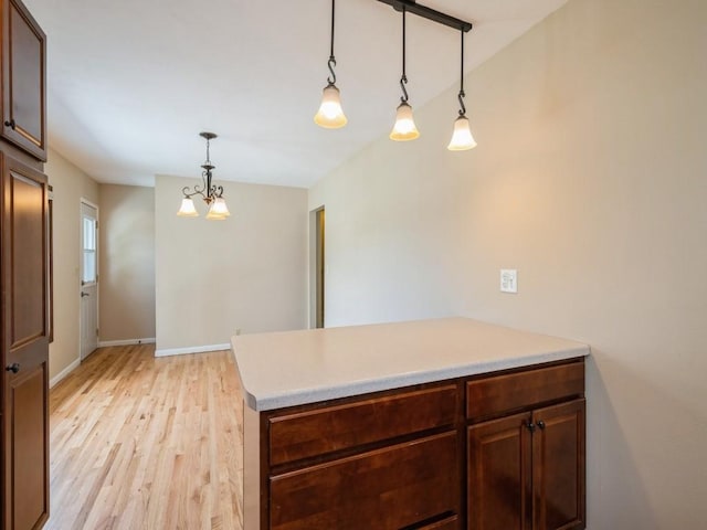 4634 Twin Pine Dr NE, Cedar Rapids, IA 52402 - kitchen with light wood-style flooring, light countertops, a peninsula, pendant lighting, and a chandelier