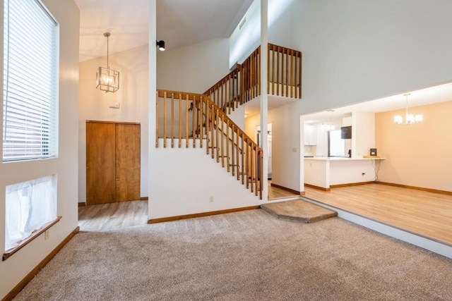3524 Swallow Ct NE, Cedar Rapids, IA 52402 - unfurnished living room featuring a chandelier, a high ceiling, carpet, and stairs