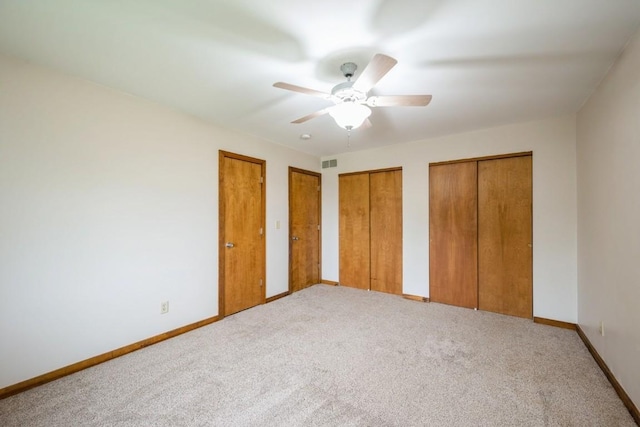 3524 Swallow Ct NE, Cedar Rapids, IA 52402 - unfurnished bedroom featuring two closets, carpet flooring, and ceiling fan