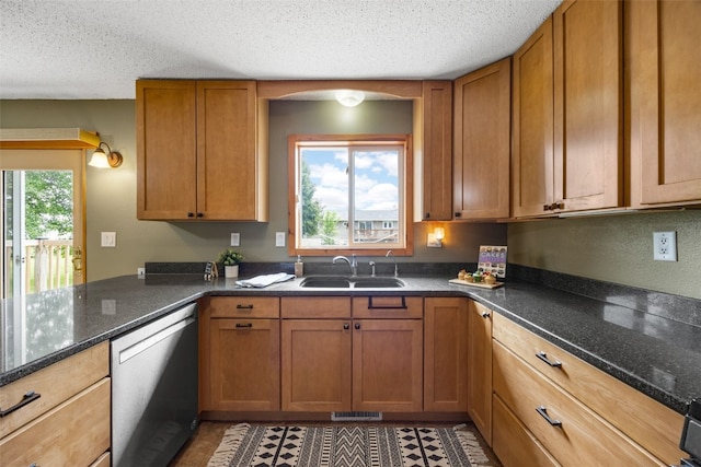 52 Thompson Dr, Palo, IA 52324 - kitchen featuring stainless steel dishwasher, brown cabinetry, dark stone counters, a textured ceiling, and a peninsula