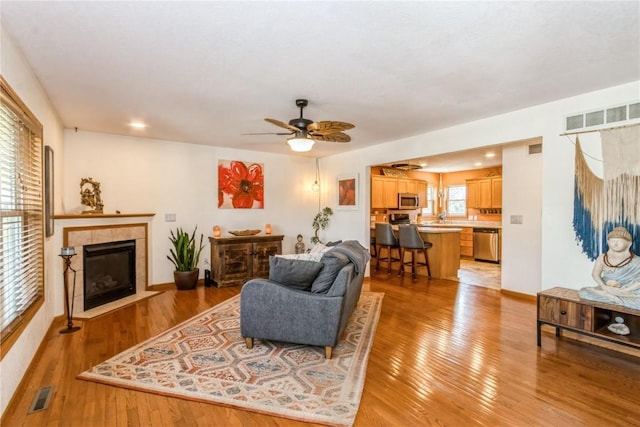 1017 Langenberg Ave, Iowa City, IA 52240 - living room with light wood finished floors, a ceiling fan, a tile fireplace, and recessed lighting