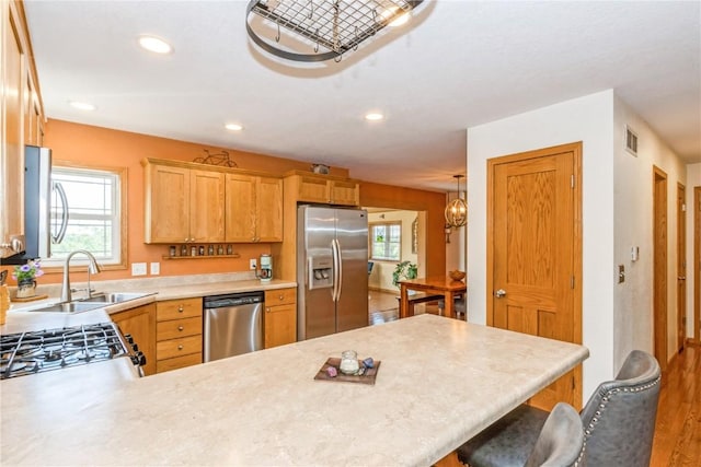 1017 Langenberg Ave, Iowa City, IA 52240 - kitchen featuring appliances with stainless steel finishes, light countertops, a peninsula, a breakfast bar area, and recessed lighting