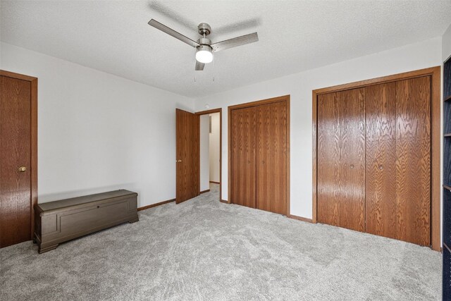 1211 Cambria Ct, Iowa City, IA 52246 - unfurnished bedroom featuring two closets, carpet floors, and a ceiling fan