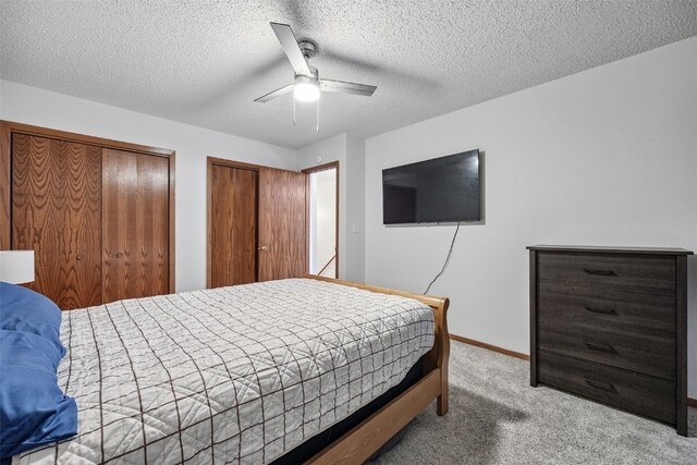 1211 Cambria Ct, Iowa City, IA 52246 - bedroom featuring carpet, two closets, ceiling fan, and a textured ceiling