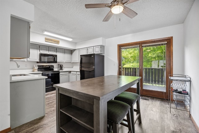 1211 Cambria Ct, Iowa City, IA 52246 - kitchen featuring black appliances, gray cabinets, a textured ceiling, light wood finished floors, and ceiling fan