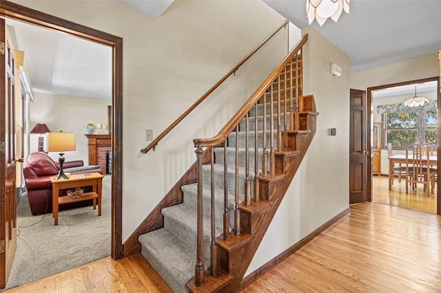 927 Southlawn Dr, Iowa City, IA 52245 - stairs featuring wood finished floors and a brick fireplace