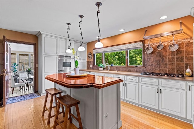 927 Southlawn Dr, Iowa City, IA 52245 - kitchen with appliances with stainless steel finishes, light wood-style floors, tasteful backsplash, and recessed lighting