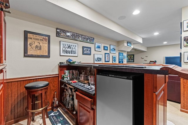 927 Southlawn Dr, Iowa City, IA 52245 - indoor dry bar featuring wainscoting, wood walls, recessed lighting, and fridge