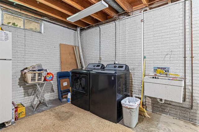 927 Southlawn Dr, Iowa City, IA 52245 - unfinished below grade area featuring washer and clothes dryer, freestanding refrigerator, and brick wall
