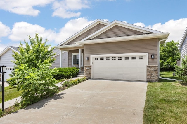 281 Danielle St, Iowa City, IA 52245 - view of front of house featuring stone siding, a front lawn, concrete driveway, and a garage