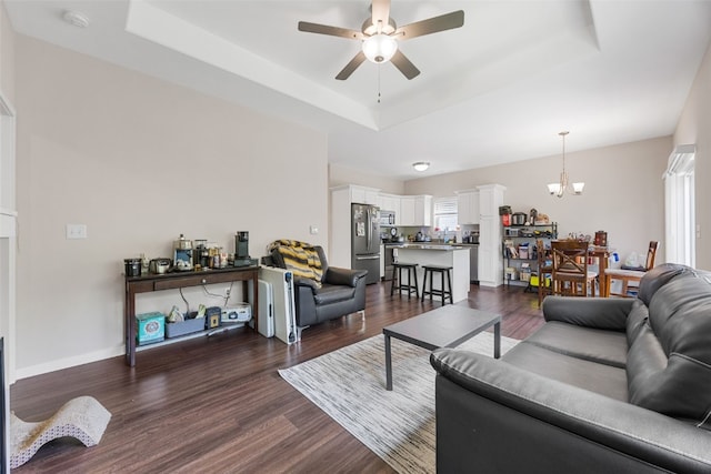 281 Danielle St, Iowa City, IA 52245 - living room featuring a tray ceiling, a ceiling fan, a chandelier, and dark wood-style floors