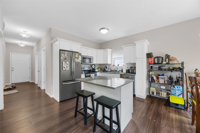 281 Danielle St, Iowa City, IA 52245 - kitchen with appliances with stainless steel finishes, dark wood-type flooring, white cabinets, and a breakfast bar area