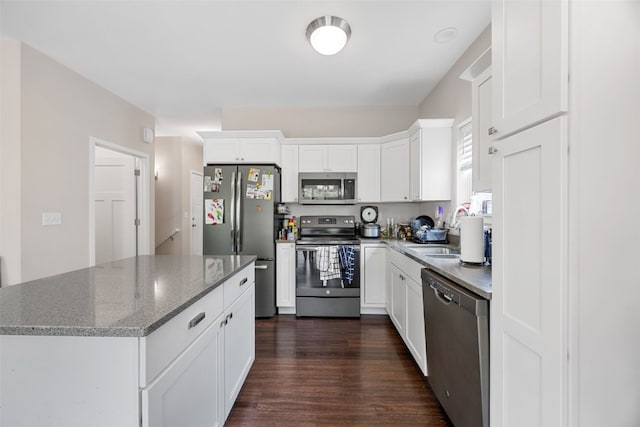 281 Danielle St, Iowa City, IA 52245 - kitchen featuring stainless steel appliances, dark wood-type flooring, white cabinetry, a center island, and light stone counters