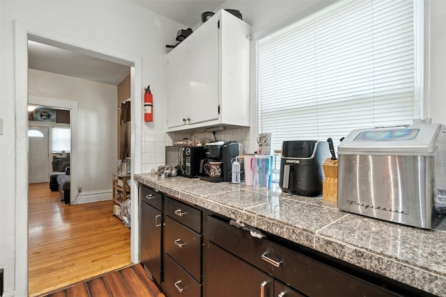 420 16th St NE, Cedar Rapids, IA 52402 - kitchen featuring tile countertops, dark wood-type flooring, dark brown cabinets, white cabinetry, and tasteful backsplash