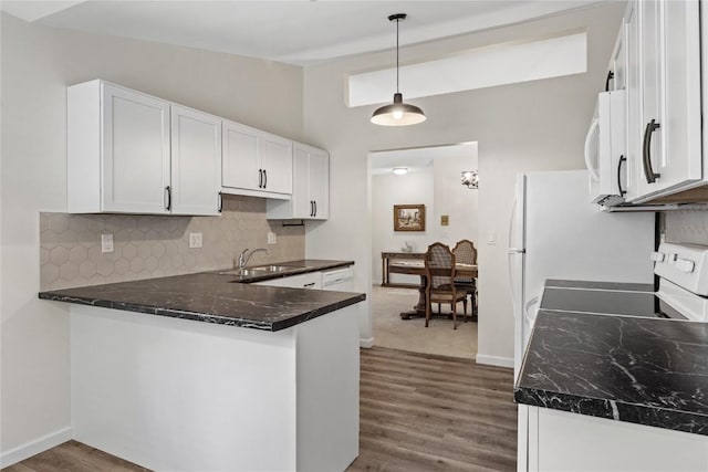 3921 Lexington Dr NE Unit C, Cedar Rapids, IA 52402 - kitchen featuring white microwave, electric stove, decorative backsplash, dark wood-type flooring, and white cabinetry