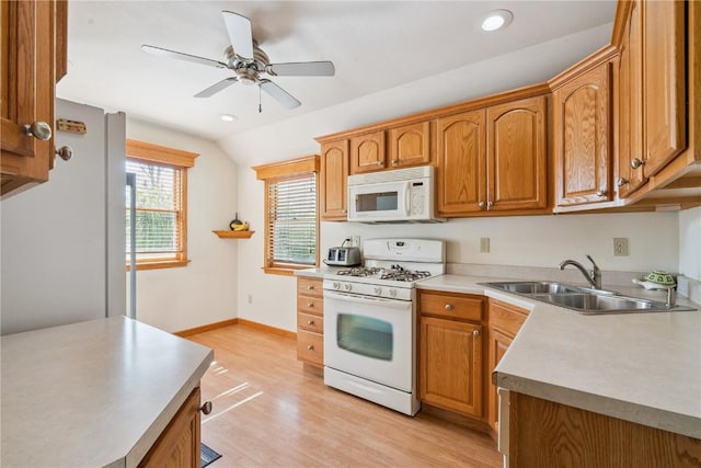 1039 31st St NE, Cedar Rapids, IA 52402 - kitchen featuring white appliances, light wood-style floors, a ceiling fan, vaulted ceiling, and brown cabinets