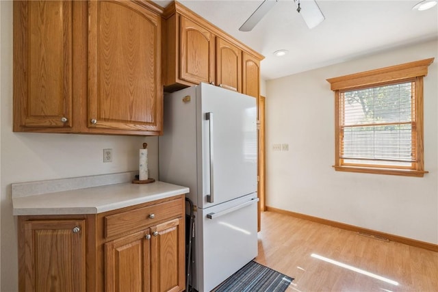 1039 31st St NE, Cedar Rapids, IA 52402 - kitchen featuring freestanding refrigerator, light wood-style flooring, light countertops, brown cabinets, and recessed lighting