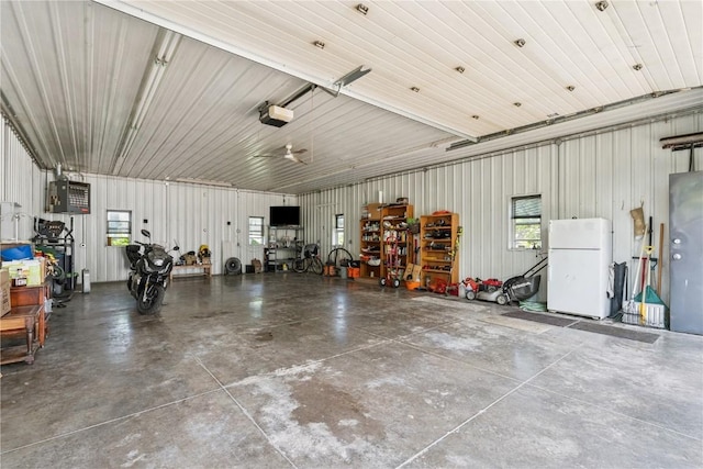 1039 31st St NE, Cedar Rapids, IA 52402 - garage with freestanding refrigerator, a garage door opener, and metal wall