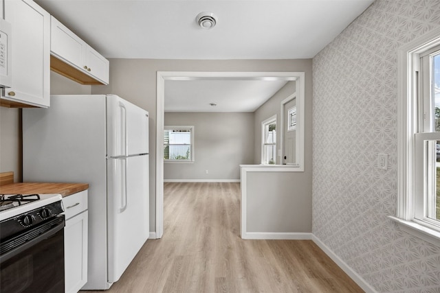 6404 Parkview Ave, Cedar Rapids, IA 52403 - kitchen featuring light wood-style floors, white cabinets, white appliances, wallpapered walls, and butcher block countertops