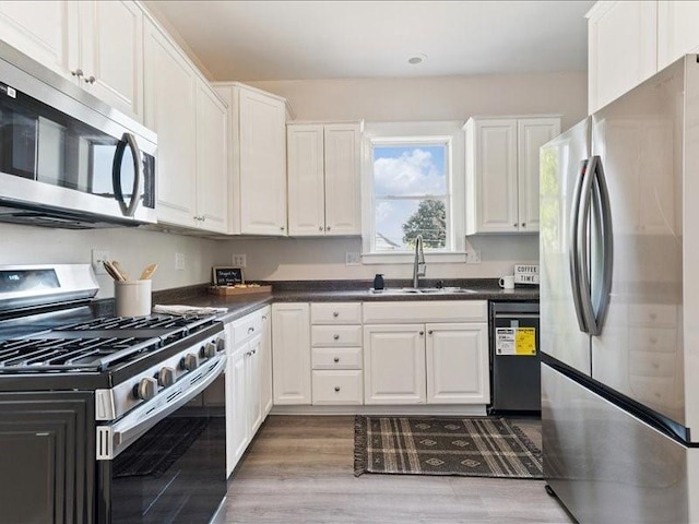 1308 A Ave NW, Cedar Rapids, IA 52405 - kitchen with stainless steel appliances, white cabinetry, dark countertops, and light wood finished floors