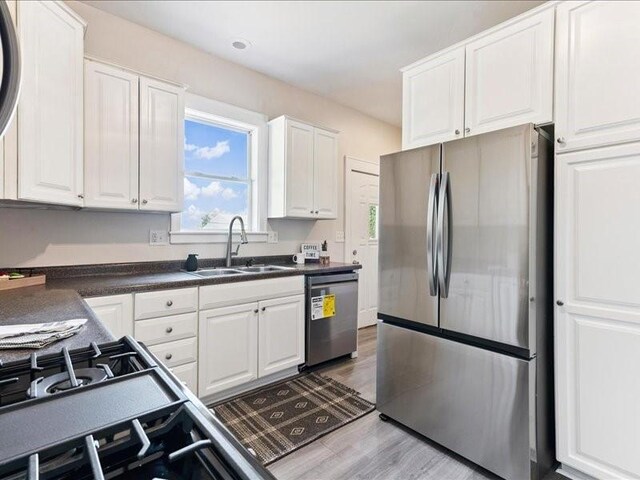 1308 A Ave NW, Cedar Rapids, IA 52405 - kitchen with stainless steel appliances, white cabinets, dark countertops, and light wood finished floors