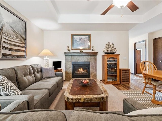 550 Meadow Oak Cir, Fairfax, IA 52228 - living room with a raised ceiling, ceiling fan, wood finished floors, a tiled fireplace, and beverage cooler