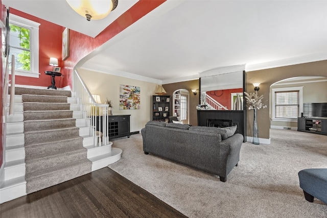 2144 Grande Ave SE, Cedar Rapids, IA 52403 - carpeted living area featuring arched walkways, a fireplace, plenty of natural light, crown molding, and stairs