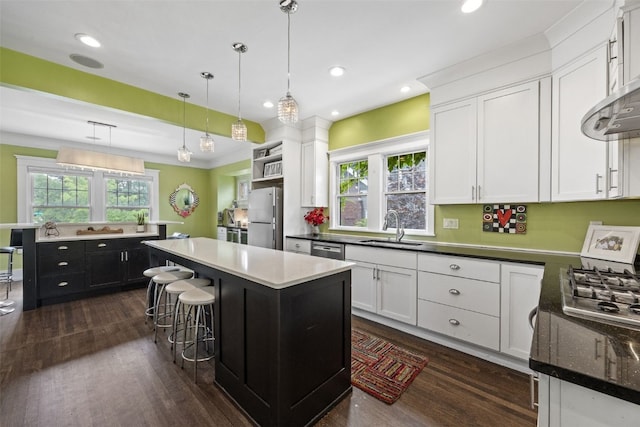 2144 Grande Ave SE, Cedar Rapids, IA 52403 - kitchen featuring appliances with stainless steel finishes, a center island, dark wood-style floors, white cabinets, and recessed lighting
